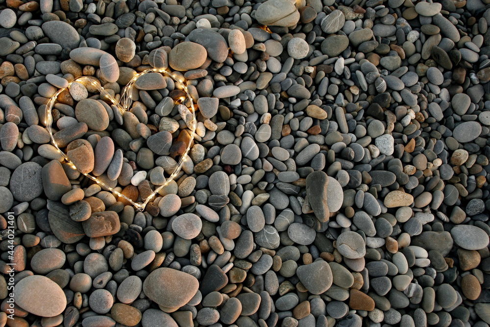 glowing heart on a background of sea pebbles glowing heart on a background of sea pebbles
