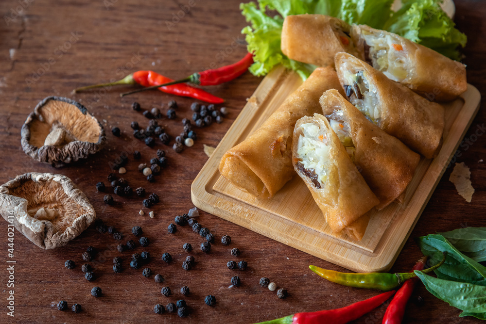 Chinese fried spring rolls on wooden background, stuffed vegetable and minced pork Chinese fried spring rolls on wooden background, stuffed vegetable and minced pork