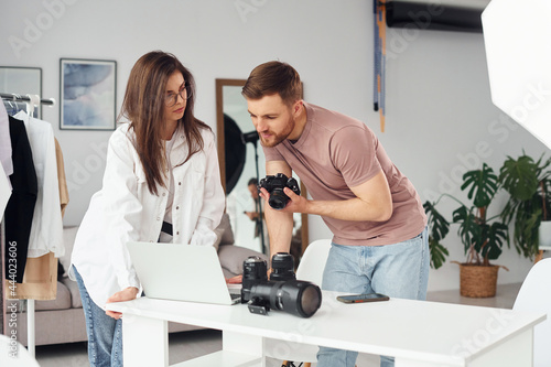 Photographers works indoors in their studio at daytime