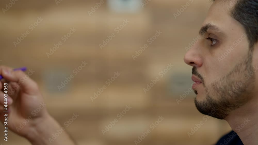 Side view face of focused professional Middle Eastern plastic surgeon measuring and marking breast of unrecognizable patient. Concentrated serious doctor preparing for aesthetic surgery in hospital Side view face of focused professional Middle Eastern plastic surgeon measuring and marking breast of unrecognizable patient. Concentrated serious doctor preparing for aesthetic surgery in hospital