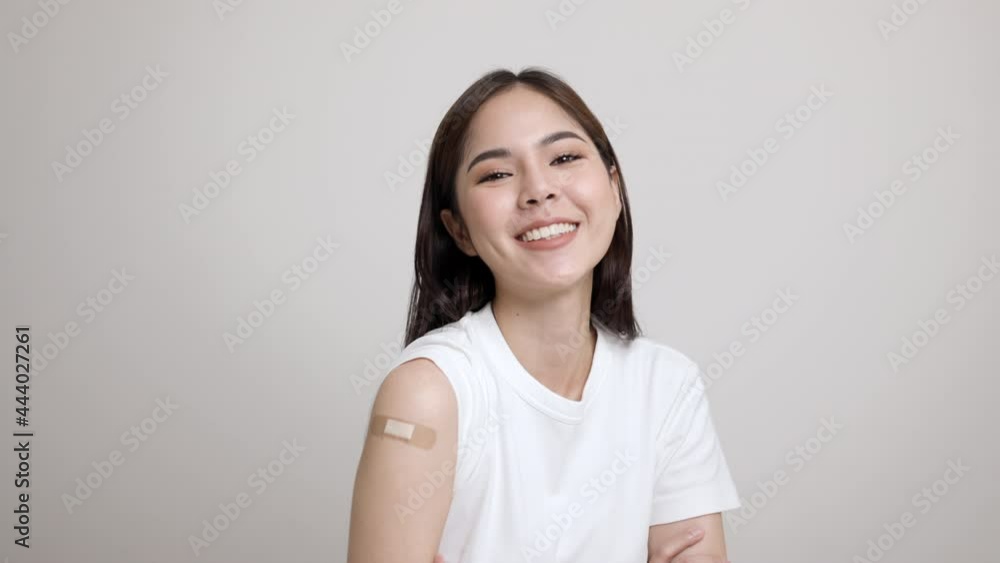 Vaccination. Young beautiful asian woman getting a vaccine protection the coronavirus. Smiling happy female showing arm with bandage after receiving vaccination. On isolated white background. Vaccination. Young beautiful asian woman getting a vaccine protection the coronavirus. Smiling happy female showing arm with bandage after receiving vaccination. On isolated white background.