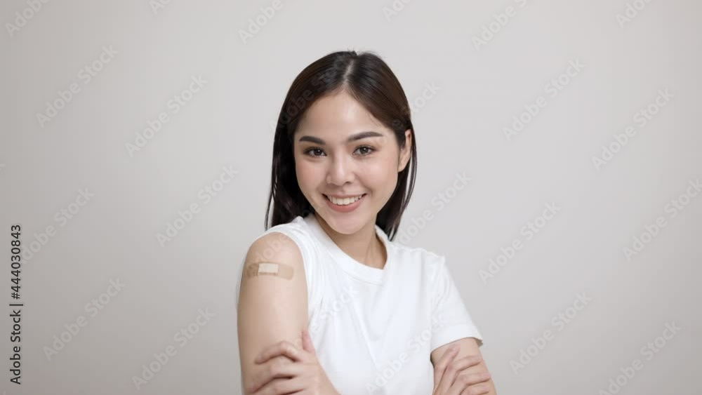 Vaccination. Young beautiful asian woman getting a vaccine protection the coronavirus. Smiling happy female showing arm with bandage after receiving vaccination. On isolated white background. Vaccination. Young beautiful asian woman getting a vaccine protection the coronavirus. Smiling happy female showing arm with bandage after receiving vaccination. On isolated white background.
