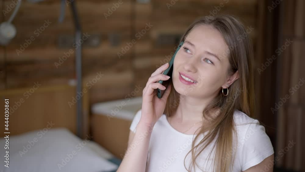 Optimistic young brunette ill woman talking on the phone laughing sitting in hospital ward. Portrait of charming positive Caucasian millennial chatting smiling. Optimism and medicine Optimistic young brunette ill woman talking on the phone laughing sitting in hospital ward. Portrait of charming positive Caucasian millennial chatting smiling. Optimism and medicine