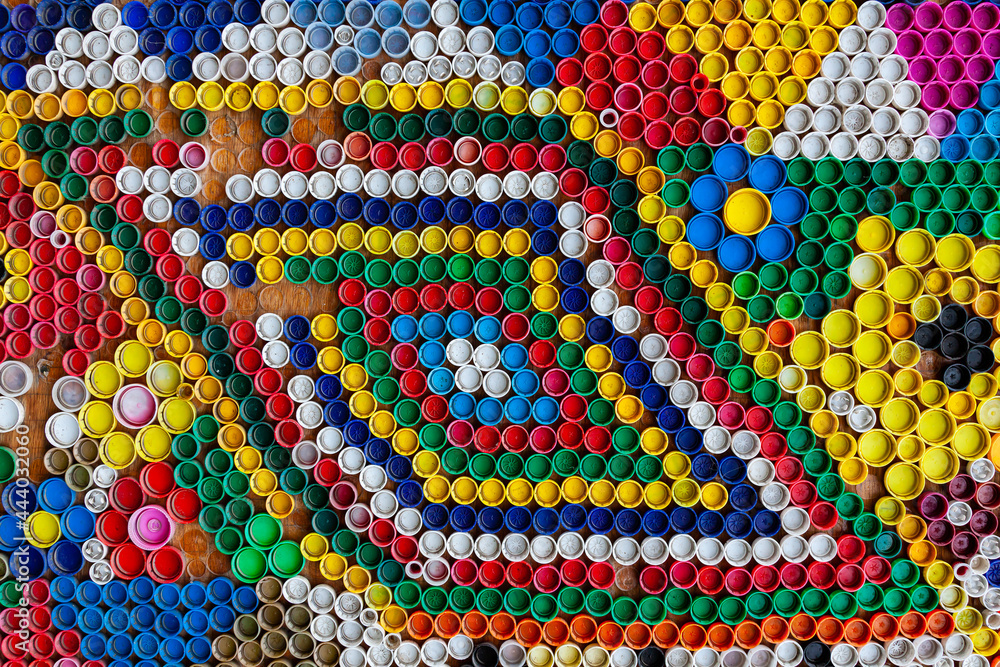 Multi-colored plastic caps from under plastic bottles, top view.
