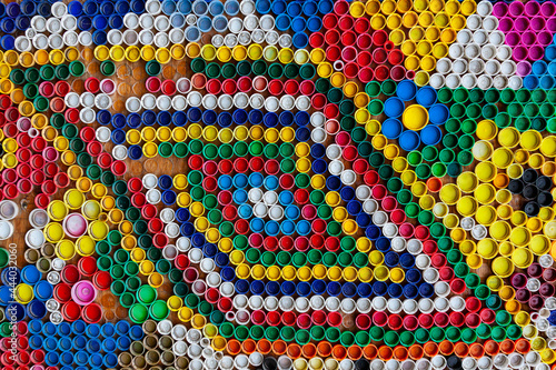 Multi-colored plastic caps from under plastic bottles, top view.