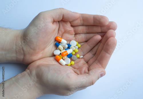 a lot of pills and tablets in the hand, consuming a lot of pills concept