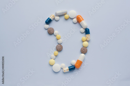 Medicine pills tablets capsules in shape of human kidney on gray background