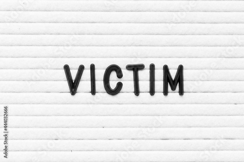 Black color letter in word victim on white felt board background