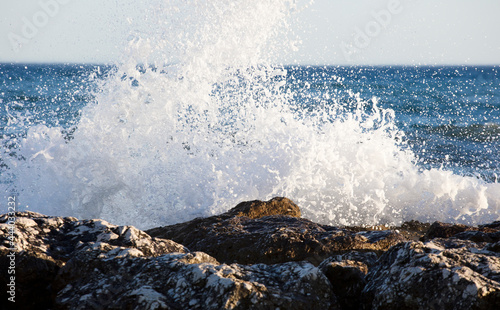 Waves splashed over rocks on a very windy day at sunset (golden hour).