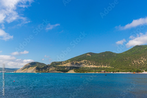 Anapa, Russia - June 11, 2021: Stony beach of Black Sea coast in Bolshoy Utrish village full of people on bright sunny summer day. Aerial view.