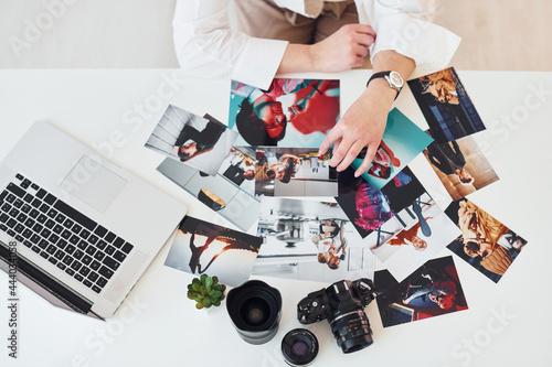 Close up view of table with camera and photos. Female photographer at work photo