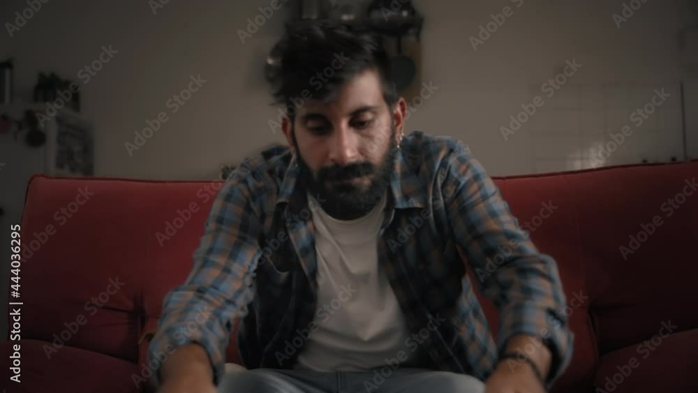 A young bearded man opening a laptop and starting to work at home, a dog sitting next to him. Slow motion. Remote working anywhere, digital nomad concept. A young bearded man opening a laptop and starting to work at home, a dog sitting next to him. Slow motion. Remote working anywhere, digital nomad concept.