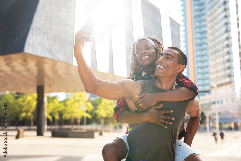 Happy smilng couple taking selfie with phone outdoors. Boyfriend and girlfriend having fun outdoors..