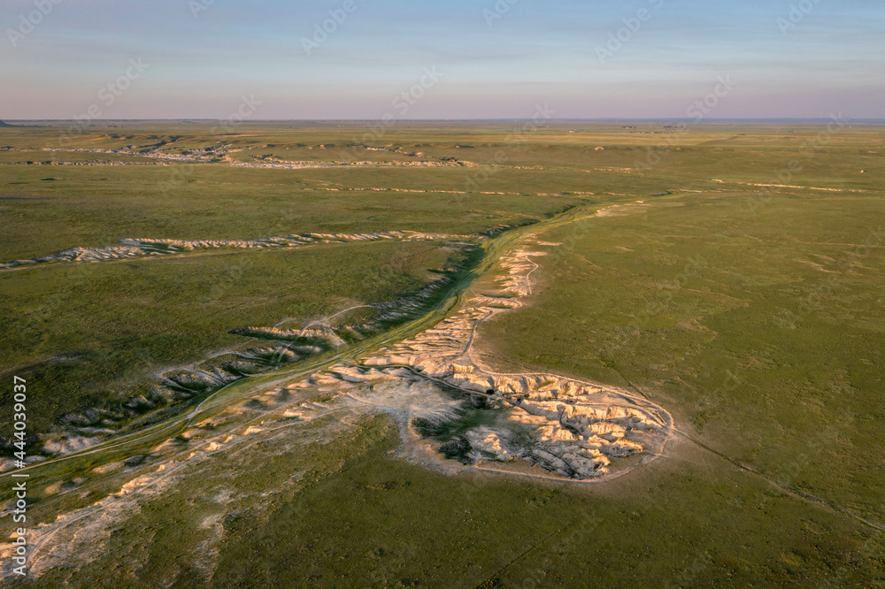 sunset light over arroyo and badlands in Pawnee National Grassland in northern Colorado, early summer scenery aerial view sunset light over arroyo and badlands in Pawnee National Grassland in northern Colorado, early summer scenery aerial view