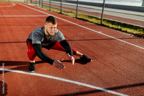 Close up photo of man is stretching outdoors, representing healthy active lifestyle model.