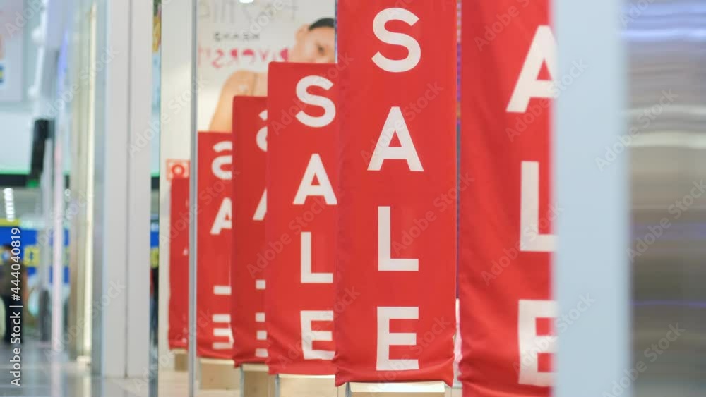 Red Sale Banners on Anti-Theft Gate Sensors at a Retail Shopping Mall Entrance. Shopping and Consumerism Concept Red Sale Banners on Anti-Theft Gate Sensors at a Retail Shopping Mall Entrance. Shopping and Consumerism Concept