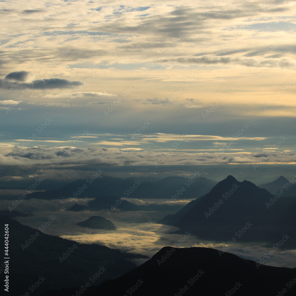 Sunrise view from Mount Brienzer Rothorn. Mount Stanserhorn and sea of fog on a cloudy summer morning.