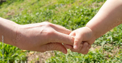 a parent holds the hand of a small child. The child is holding his mother's hand. The concept of the Children's Day . Children's Day, Mother's Day