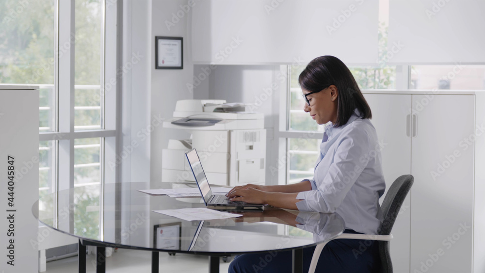 Portrait of cheerful african businesswoman sitting at table in office Portrait of cheerful african businesswoman sitting at table in office