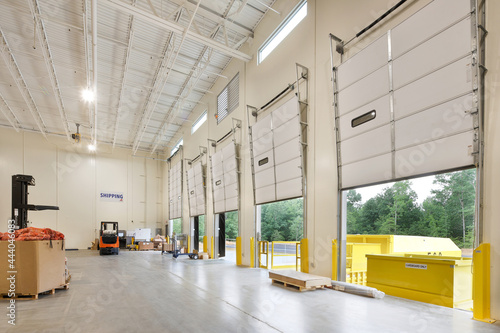 Interior of garage storage building with forklifts and wall of entrances