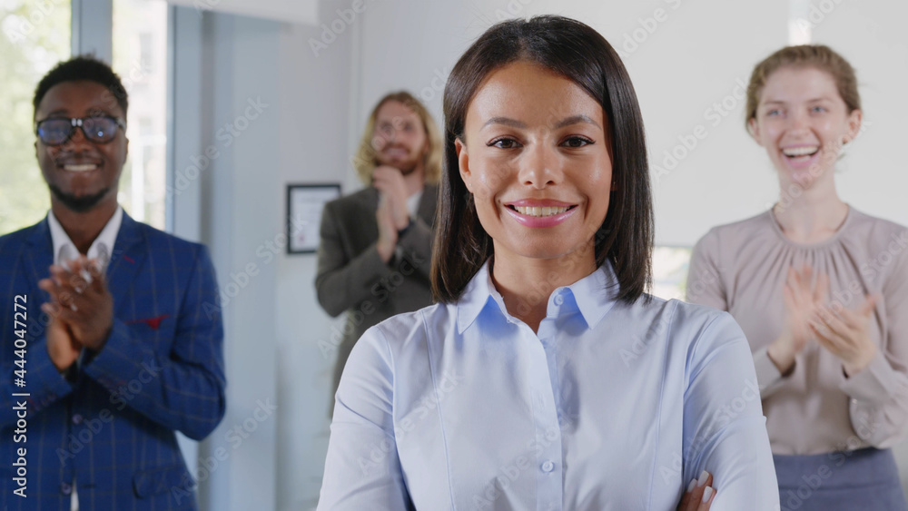 Portrait of confident african businesswoman and team applauding on background smiling at camera Portrait of confident african businesswoman and team applauding on background smiling at camera