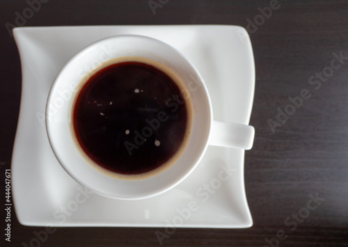 White cup of hot drink on a wooden background