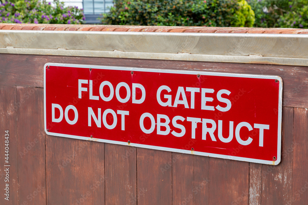 A sign on a flood gate that reads flood gates do not obstruct A sign on a flood gate that reads flood gates do not obstruct