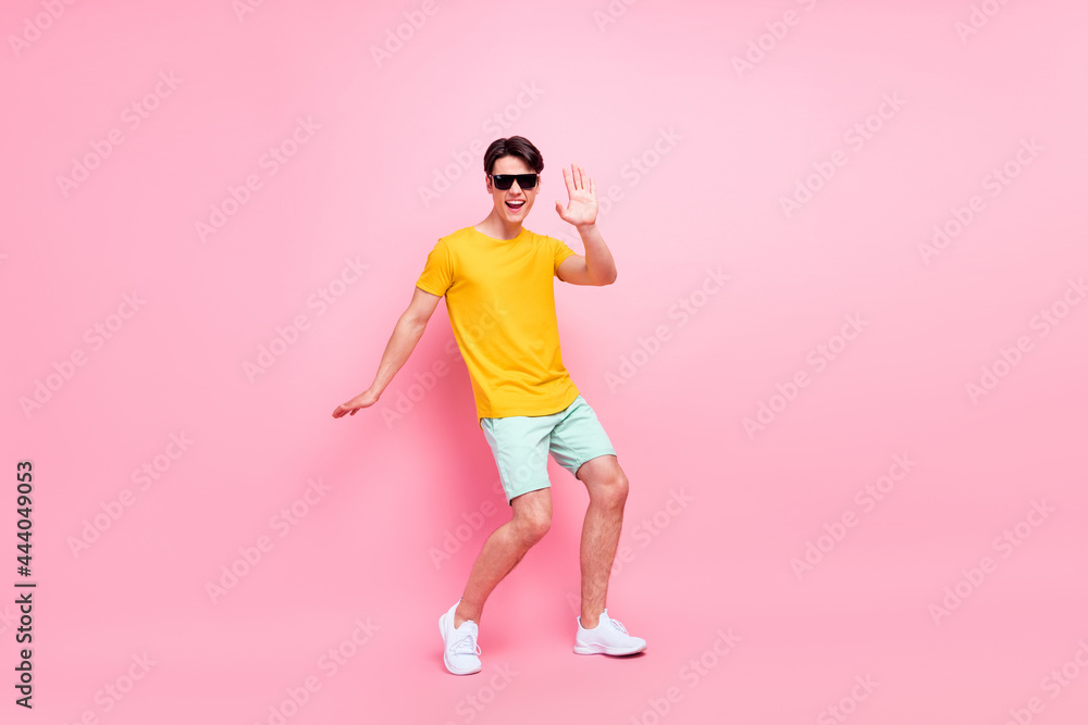 Photo of carefree disco cheerful guy dance beach party wear yellow t-shirt shorts isolated on pink background