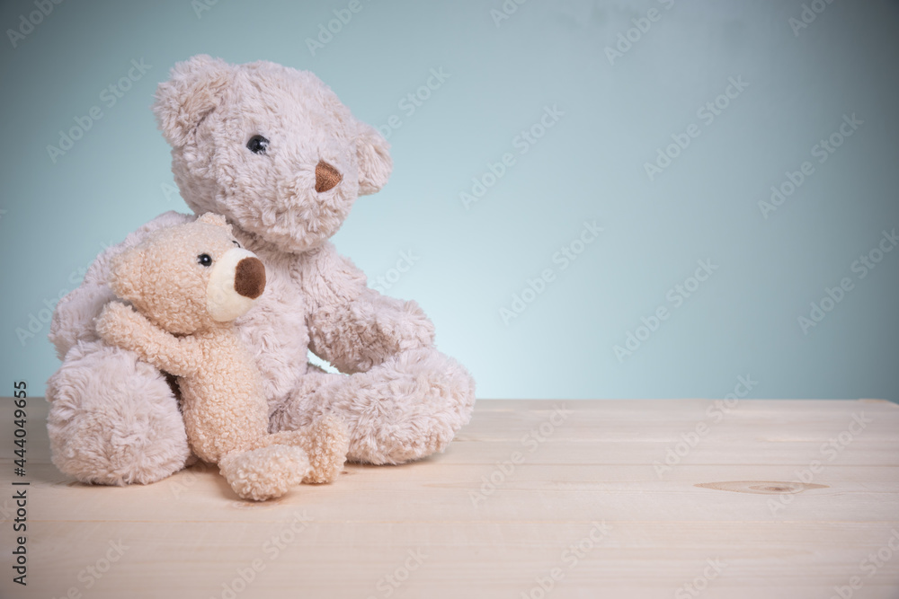 Big and little brown teddy bears sitting huggy show love, happiness on an old wooden table with copy space. Concept family, love, and valentines festival. Big and little brown teddy bears sitting huggy show love, happiness on an old wooden table with copy space. Concept family, love, and valentines festival.