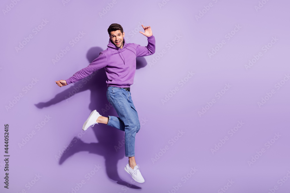Full length body size view of attractive funny cheerful guy jumping having fun isolated over purple violet color background Full length body size view of attractive funny cheerful guy jumping having fun isolated over purple violet color background