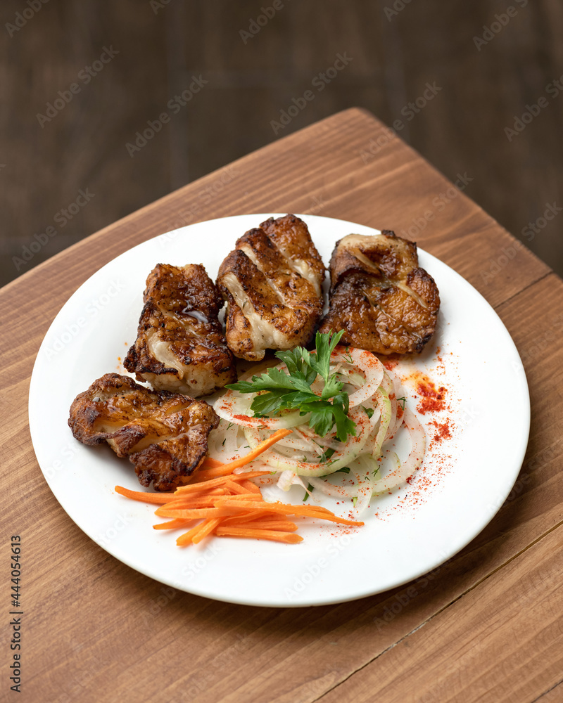 Fried juicy meat fillet with salad. Food plate on wooden table. Vertical format. Soft focus. Copy space. Fried juicy meat fillet with salad. Food plate on wooden table. Vertical format. Soft focus. Copy space.