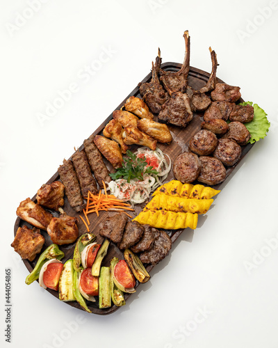 Large tray of mixed grilled meat and vegetables . Tasty dinner. Top view. Vertical format.