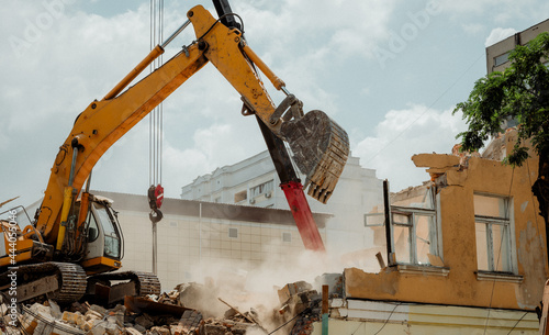 Foto A construction bulldozer demolishes an old house on a clear day