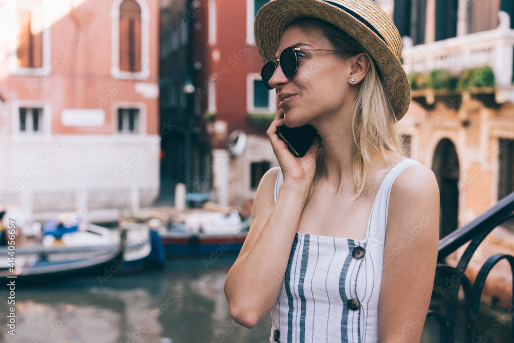 Fototapeta premium Cheerful woman talking on smartphone