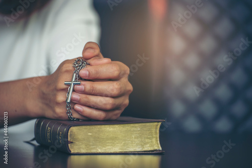 Prayer and bible concept. Asian female praying, hope for peace and free from coronavirus, Hand in hand together by woman, believes and faith in christian religion at church.
