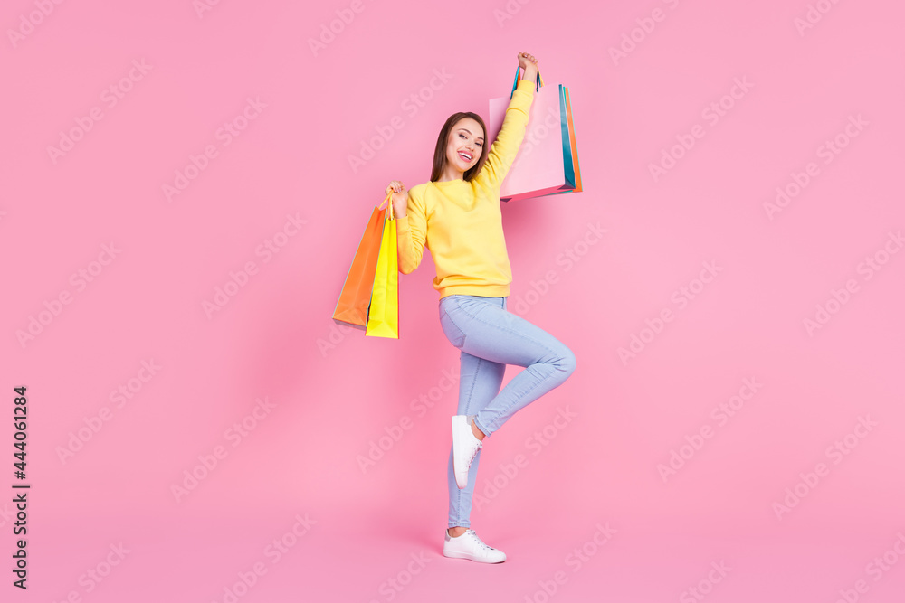 Full length body size photo smiling girl doing shopping in center keeping bags isolated pastel pink color background Full length body size photo smiling girl doing shopping in center keeping bags isolated pastel pink color background