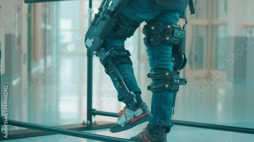 Male patient is trying to walk in the exoskeleton photo