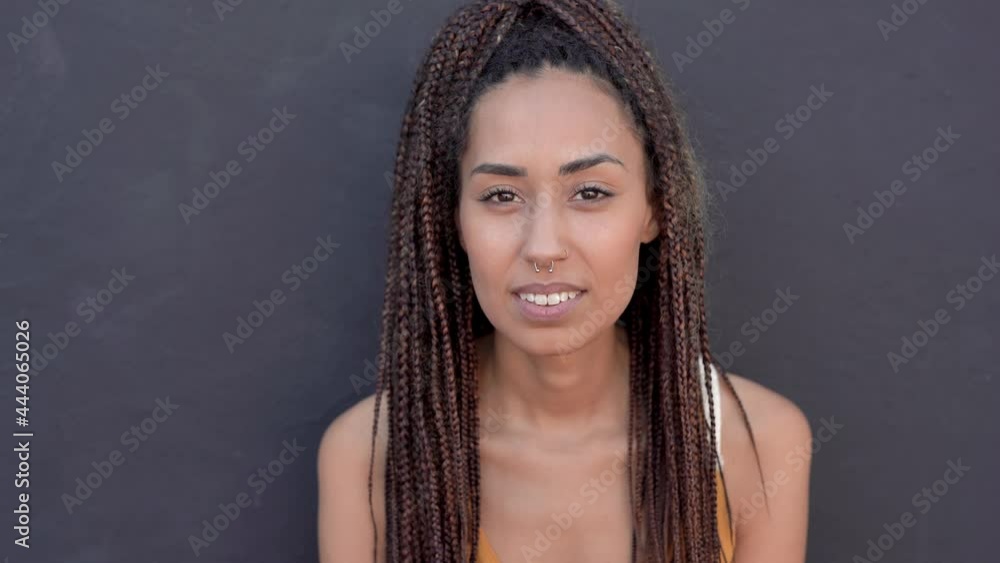 Beautiful mixed race young woman with braids looking on camera - Black background Beautiful mixed race young woman with braids looking on camera - Black background