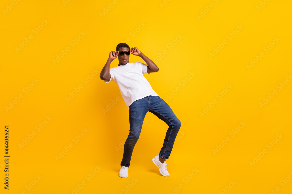 Full length body size view of attractive funky guy dancing having fun touching specs isolated over bright yellow color background