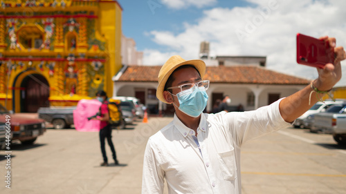 Portrait of a handsome young man taking a selfie in the park of San Andres Xecul, Guatemala. photo