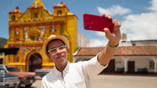 Portrait of a handsome young man taking a selfie in the park of San Andres Xecul, Guatemala. photo