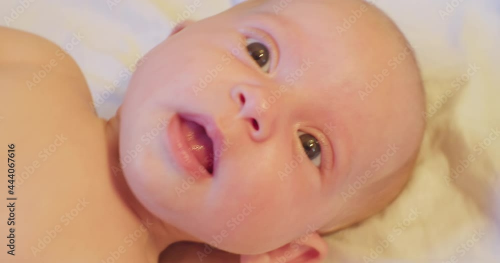 portrait of a small cute funny child who lies in his bed and looks up with surprise. close-up. portrait of a small cute funny child who lies in his bed and looks up with surprise. close-up.