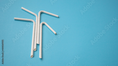 Biodegradable eco friendly white paper drinking straw on blue background
