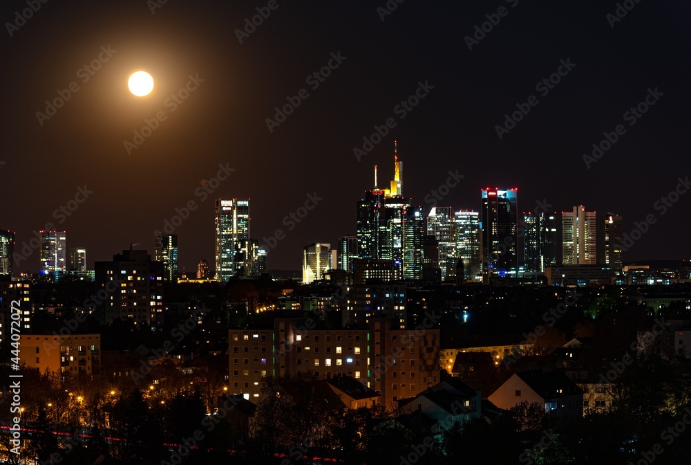 Beautiful view on  Frankfurt am Main (european finance center city) downtown skyline cityscape. Moon, supermoon during twilight blue hour, sunset, evening, night. Travel in Hesse. Hessen, Germany.