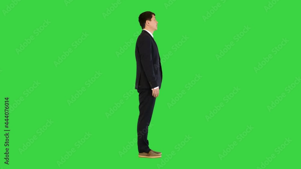 Asian man in office suit making a bow on a Green Screen, Chroma Key. Asian man in office suit making a bow on a Green Screen, Chroma Key.