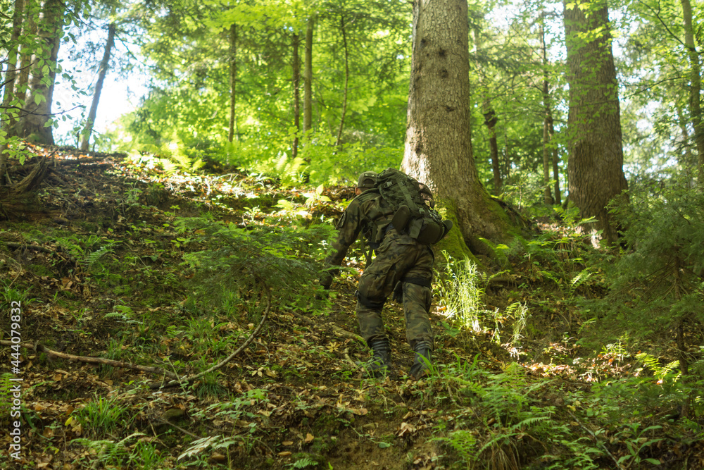 young soldier in military outfit climbing on a steep slope young soldier in military outfit climbing on a steep slope