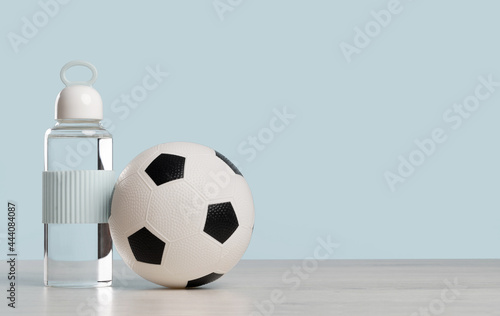 Football. Soccer ball with glass water bottle. Blue banner with copy space. School sports education or classes tournament. Gym