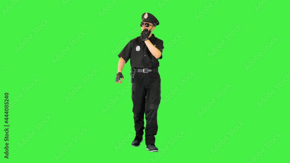 Caucasian policeman walks sending a message with radio on a Green Screen, Chroma Key. Caucasian policeman walks sending a message with radio on a Green Screen, Chroma Key.