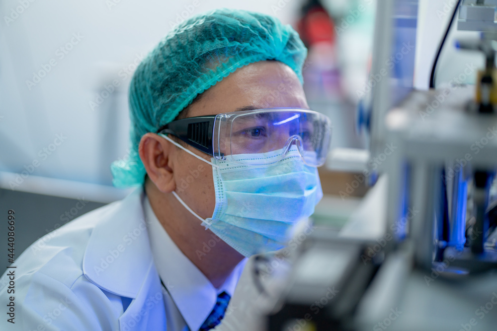 Close up face of factory worker touch protective eye glasses and look into part of machine. Close up face of factory worker touch protective eye glasses and look into part of machine.