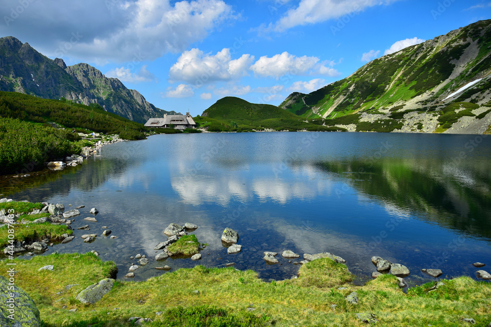 The beautiful lake Przedni Staw and the mountain lodge Schronisko Piec Stawow in the High Tatras, Poland.